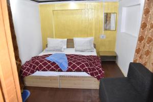 a small bedroom with a bed with a comforter at Mir guest house in Pahalgām
