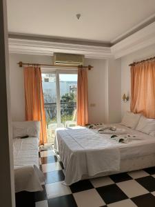 a bedroom with two beds and a window at London House Hotel in Kemer
