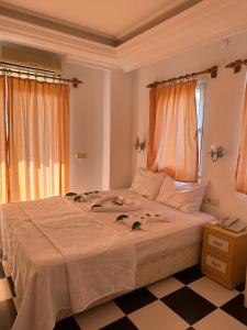a bedroom with a large white bed and a window at London House Hotel in Kemer