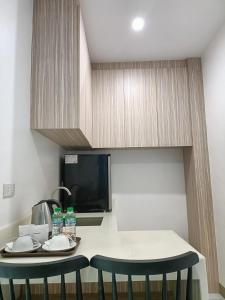 a kitchen with two chairs and a table with a microwave at Rosh Hotel in Manila