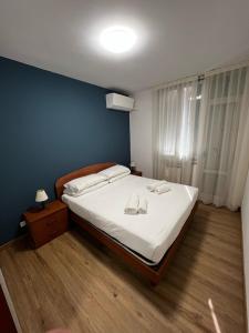 a bedroom with a bed with white sheets and a blue wall at Apartment Cornicello with pool by Glam in Bardolino +18 photos