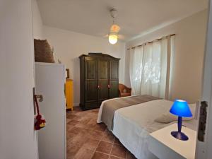 um quarto com uma cama e um candeeiro azul sobre uma mesa em La Casa Di Aceste em San Vito lo Capo