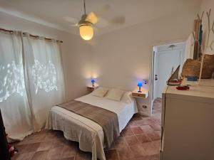 ein Schlafzimmer mit einem Bett mit zwei Lampen und einem Fenster in der Unterkunft La Casa Di Aceste in San Vito lo Capo