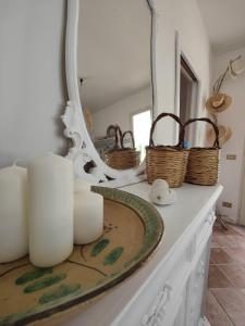 um balcão de casa de banho com espelho e cestos em La Casa Di Aceste em San Vito lo Capo
