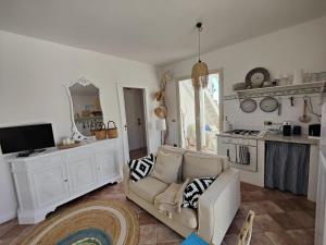 een woonkamer met een witte bank en een tv bij La Casa Di Aceste in San Vito lo Capo
