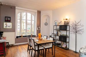 a living room with a table and chairs and a window at La Ferblanterie in Rambervillers