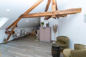 una sala de estar con vigas y sillas de madera. en La Ferblanterie, en Rambervillers