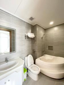 富國的住宿－Cam Hotel Phu Quoc，浴室配有卫生间、浴缸和水槽。