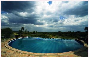 una gran piscina bajo un cielo nublado en Jacaranda Bush Camp, en Musiara Campsite