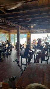 eine Gruppe von Personen, die in einem Restaurant an Tischen sitzen in der Unterkunft Bong's Guesthouse M'Pai Bay in Koh Rong Sanloem
