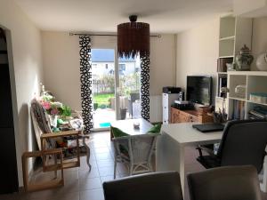 sala de estar con mesa y sillas y cocina en Coquelicot, en Hermanville-sur-Mer