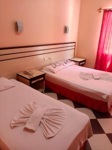 Beldibi的住宿－Santana Hotel，两张床铺,位于酒店房间,上面有弓形领带