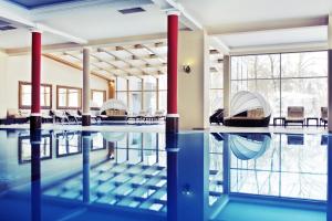 uma piscina interior com água azul em Pałac Żelechów Spa & Wellness em Zelechów