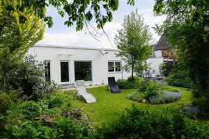 einen Garten mit zwei Stühlen und ein Haus in der Unterkunft Ferienhaus Refugium in Michelstadt