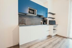 a kitchen with blue cabinets and a sink at AL 13 - Lakeside Leisure & Business in Stresa +30 photos