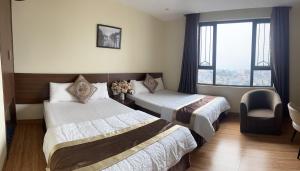 a hotel room with two beds and a window at Song Kieu Hotel - Self check-in in Ha Long