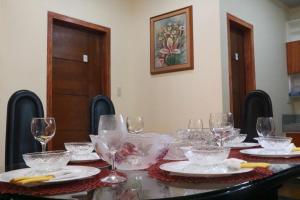 a table with glasses and plates on it at Anicia Guesthouse Units in Manila