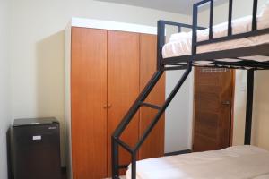 a bedroom with a bunk bed and a wooden cabinet at Anicia Guesthouse Units in Manila