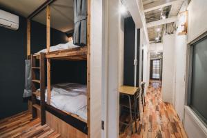 Cette chambre comprend deux lits superposés et un bureau. dans l'établissement コトリ コワーキング&ホステル高松, à Takamatsu