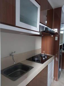 una cucina con lavandino e forno a microonde di Fully Furnished 2BR exclusive pool view apartment in Medan a Medan