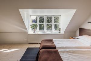 um quarto branco com uma cama e uma janela em Hotel Skeppsholmen, Stockholm, a Member of Design Hotels em Estocolmo