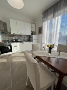 eine Küche mit weißen Schränken sowie einem Tisch und Stühlen in der Unterkunft Porpora_Apartment in Florenz