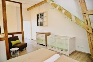 a loft bedroom with a crib and a chair at Ferienhof König - keine Vermietung an Monteure in Neukirch