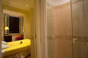 a bathroom with a shower and a bed in a room at Hotel Giolitti in Rome