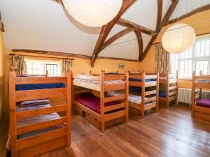 Una habitación con literas y una mesa y sillas. en Wick Court Farm, en Gloucester