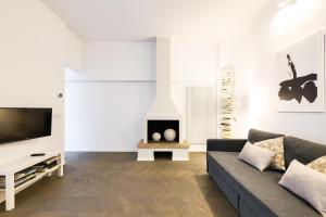 salon z kanapą i telewizorem z płaskim ekranem w obiekcie PRESTIGE BOUTIQUE HOMES - il Nido dei Navigli w Mediolanie