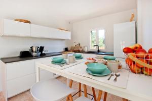 a kitchen with a table with a bowl of fruit on it at Villa Domingos by Slow Villas in Calas de Mallorca