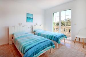 卡拉斯馬略卡的住宿－Villa Domingos by Slow Villas，白色客房的两张床,设有窗户