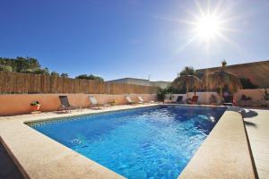 a swimming pool with chairs and the sun in the background at Villa Domingos by Slow Villas in Calas de Mallorca