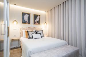Schlafzimmer mit einem großen weißen Bett und Vorhängen in der Unterkunft Machim D'Arfet House by Madeira Sun Travel in Machico