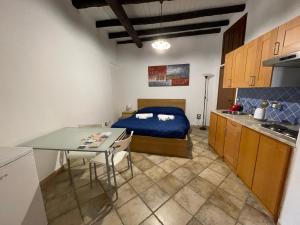 巴勒摩的住宿－Baglio Judica Apartments，一间卧室配有一张床铺和一张桌子,还设有一间厨房