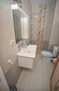 een badkamer met een wastafel, een toilet en een spiegel bij Maison D'hôte Dar Saida in Sicca Veneria
