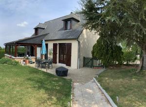 una casa con tavolo e ombrellone in cortile di Rue Veillon a Céaux