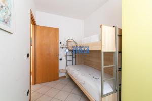 a bunk bed in a room with a ladder at Villa Alpina in Lido di Jesolo