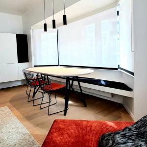 een eetkamer met een tafel en 2 stoelen bij Cofa'sea designvol appartement in Knokke-Heist