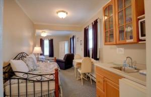 cocina y sala de estar con 1 cama en una habitación en Carriage House Motel Cottages & Suites en Wells