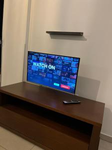 a television on a wooden table with a remote control at NINA COURT Residence - University of Cyprus - Aglantzia in Aglantzia