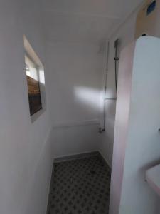 ein kleines weißes Bad mit einem Fenster und einem Boden in der Unterkunft Larmar bed and breakfast in Puerto Princesa