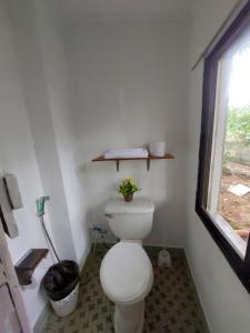 ein kleines Bad mit einem WC und einem Fenster in der Unterkunft Larmar bed and breakfast in Puerto Princesa