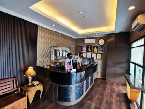 two men standing at a bar in a hotel lobby at Goodhope Hotel Shah Alam in Shah Alam