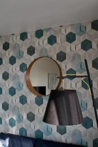 a room with a mirror and a lamp and a wall at Lucaya in Koksijde