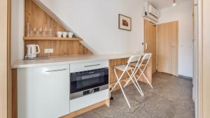 a kitchen with white cabinets and a stove top oven at Apartamenty Sun & Snow Żeromskiego II in Hel