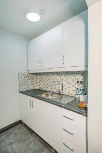 a kitchen with white cabinets and a sink at Hotel Fresia Istanbul in Istanbul