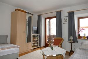 una pequeña sala de estar con cama y silla en Haus Huber, Waltraud Huber, en Marquartstein