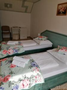 two beds in a hotel room with flowers on them at Pensiunea Ca La Mama Acasa in Reşiţa
