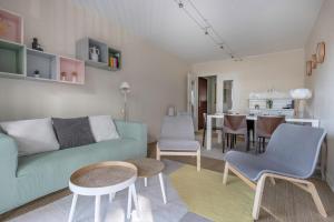 uma sala de estar com um sofá, cadeiras e uma mesa em Charmant appartement a 200 m de la mer! em Pornichet